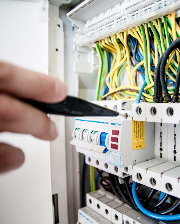 An electrician installing an electrical panel